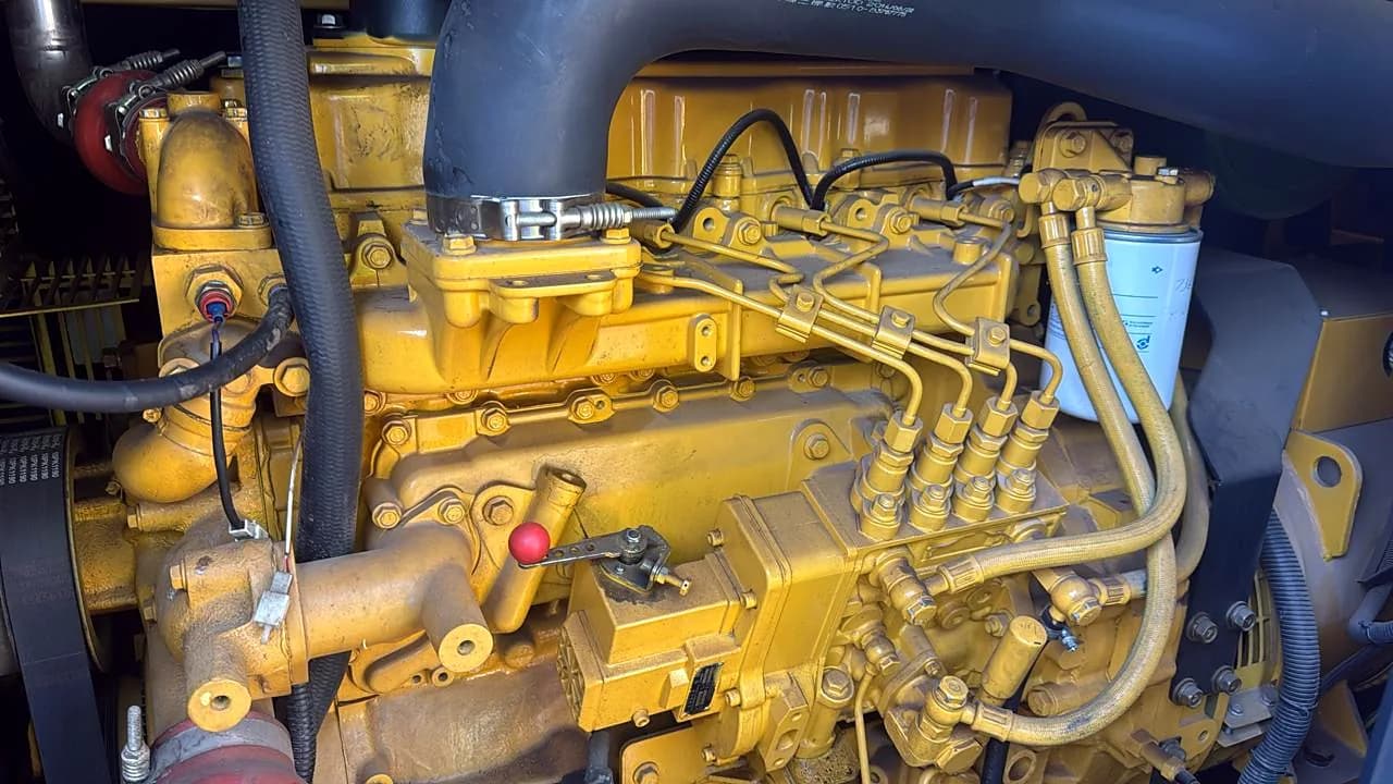 Close-up of a yellow diesel engine with its fuel injection pump and injector pipes