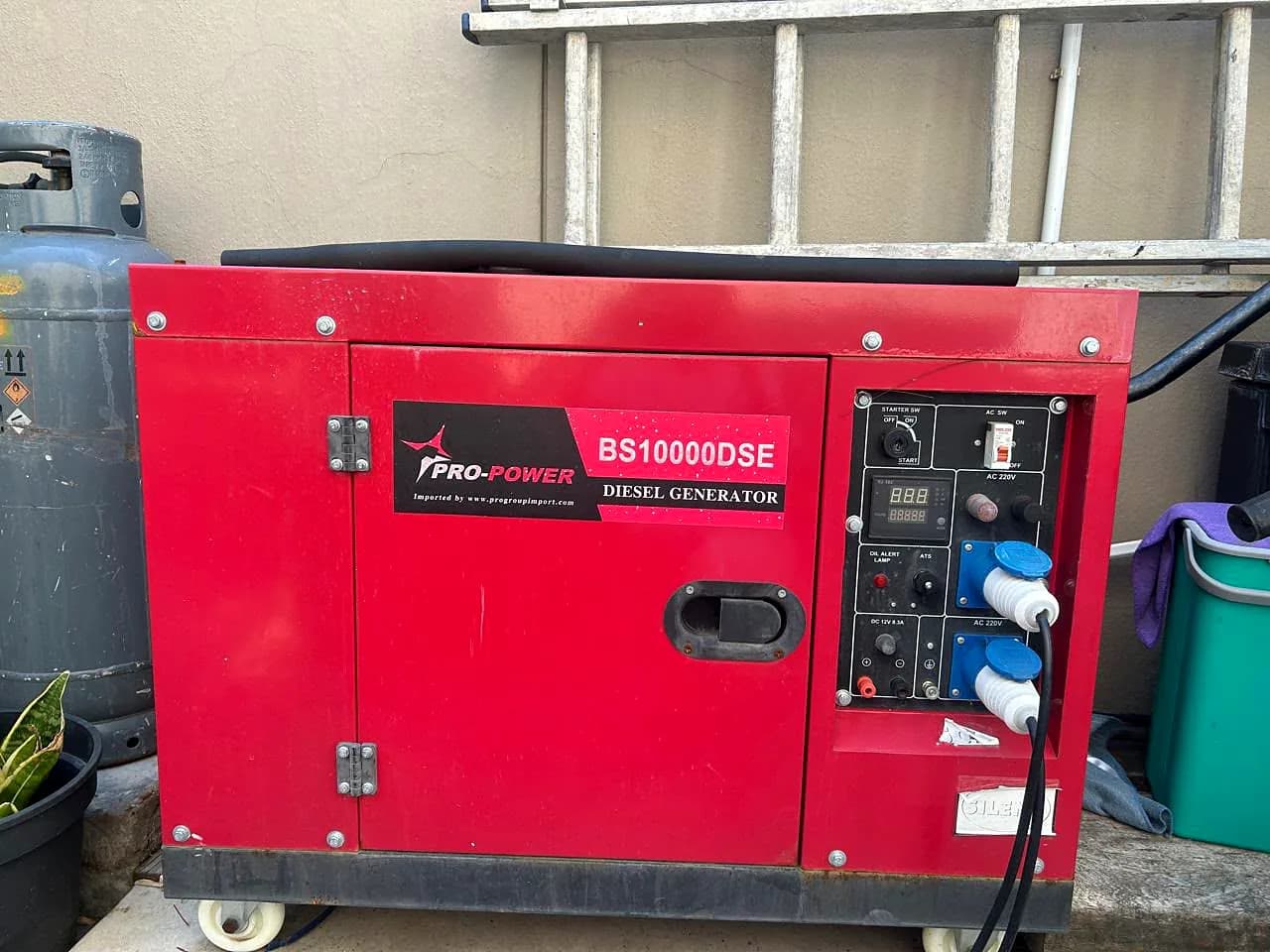 Red Pro-Power BS10000DSE silent diesel generator with a digital meter and industrial sockets on its control panel